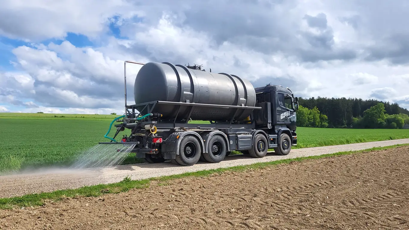 Tanklaster sorgt für Staubbindung und Verdichtung auf dem Feldweg